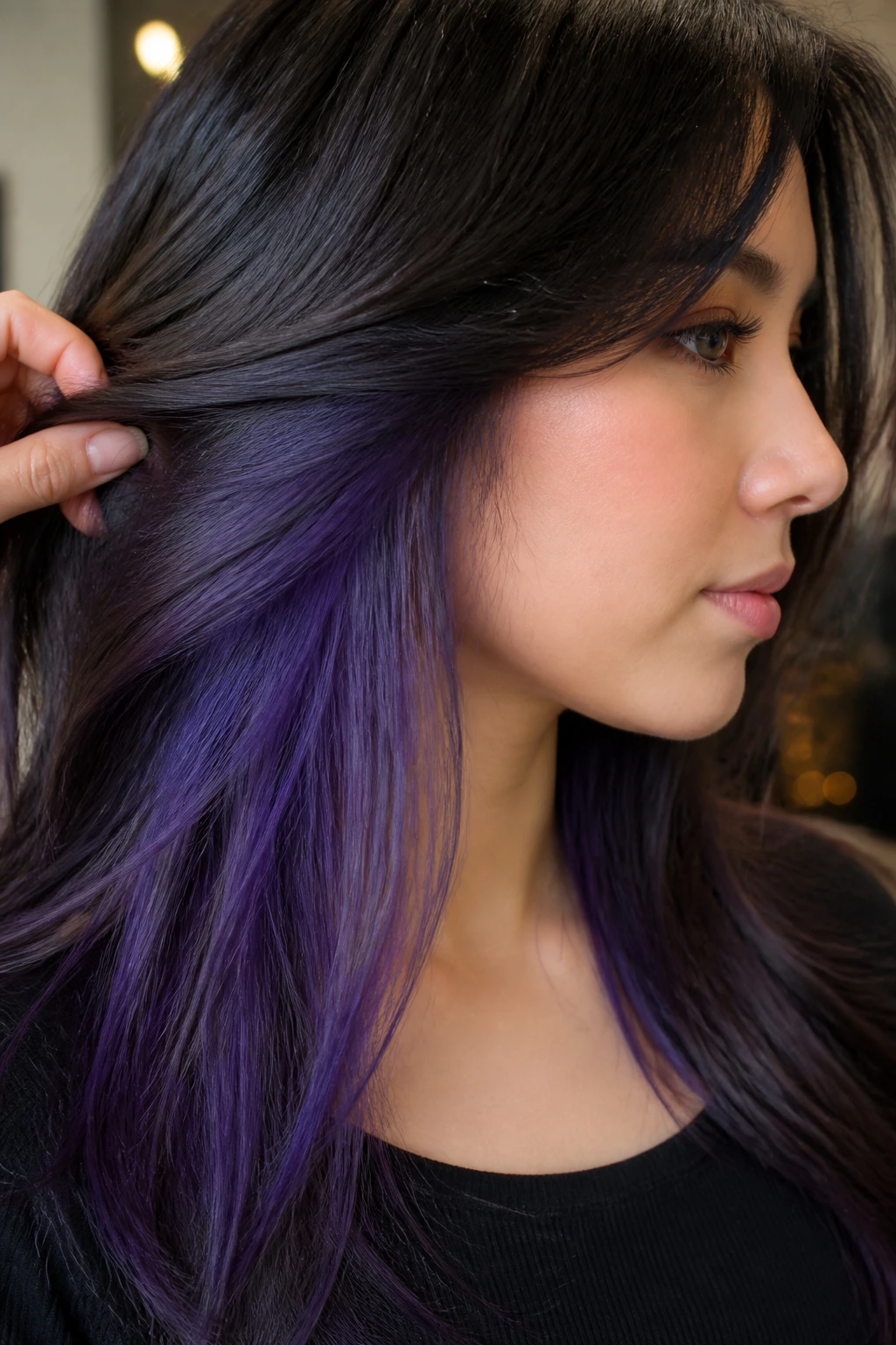 Close-up of a real person with amethyst purple peekaboo in dark brown hair