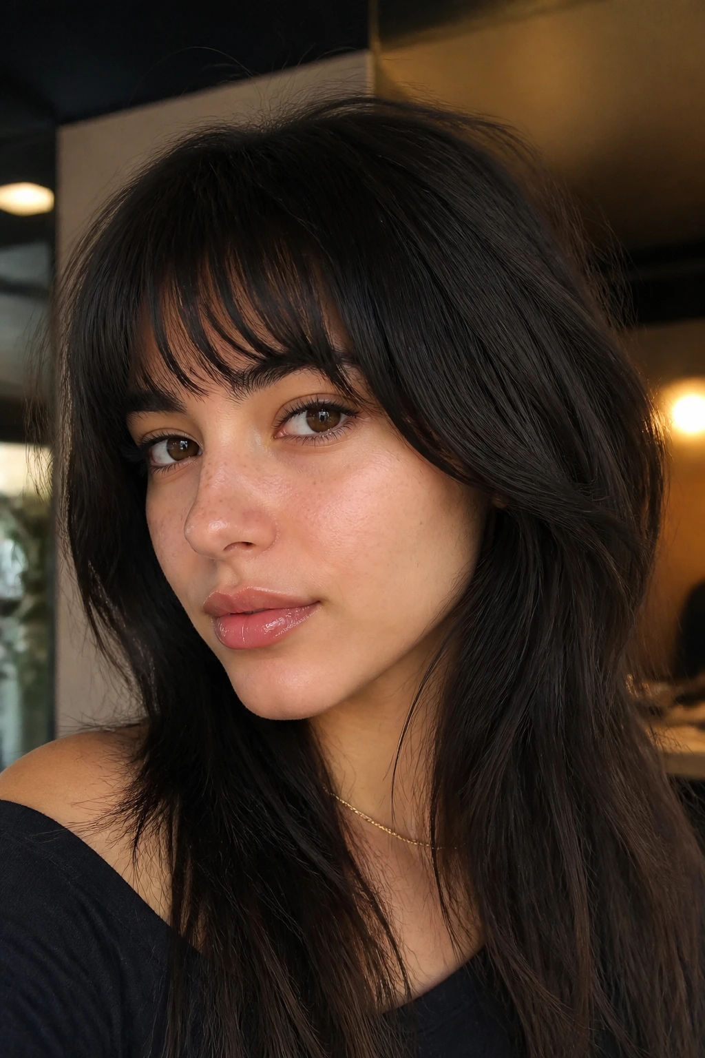 Close-up of a real woman with arched bangs along the brow line