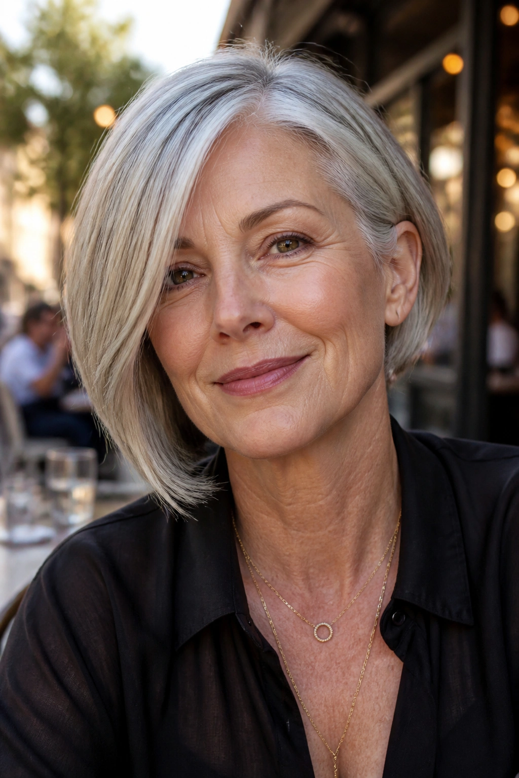 Close-up portrait of a real woman with an asymmetrical bob and gray hair.