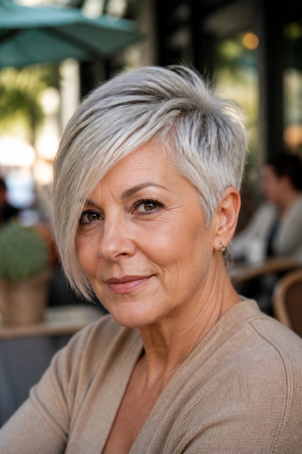 Portrait of woman with asymmetrical pixie, longer side and diagonal fringe outdoors.