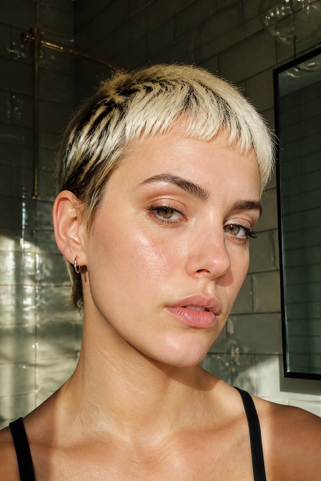Close-up of a person with bleached baby bangs framed by a bright forehead.