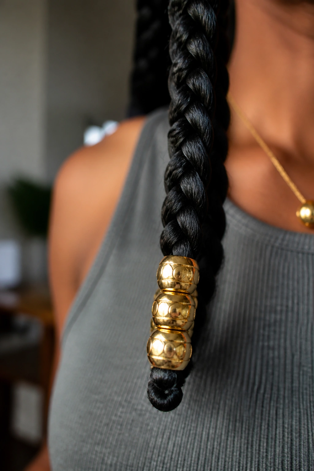 Beads at the end of a long braid on a real person with natural indoor light