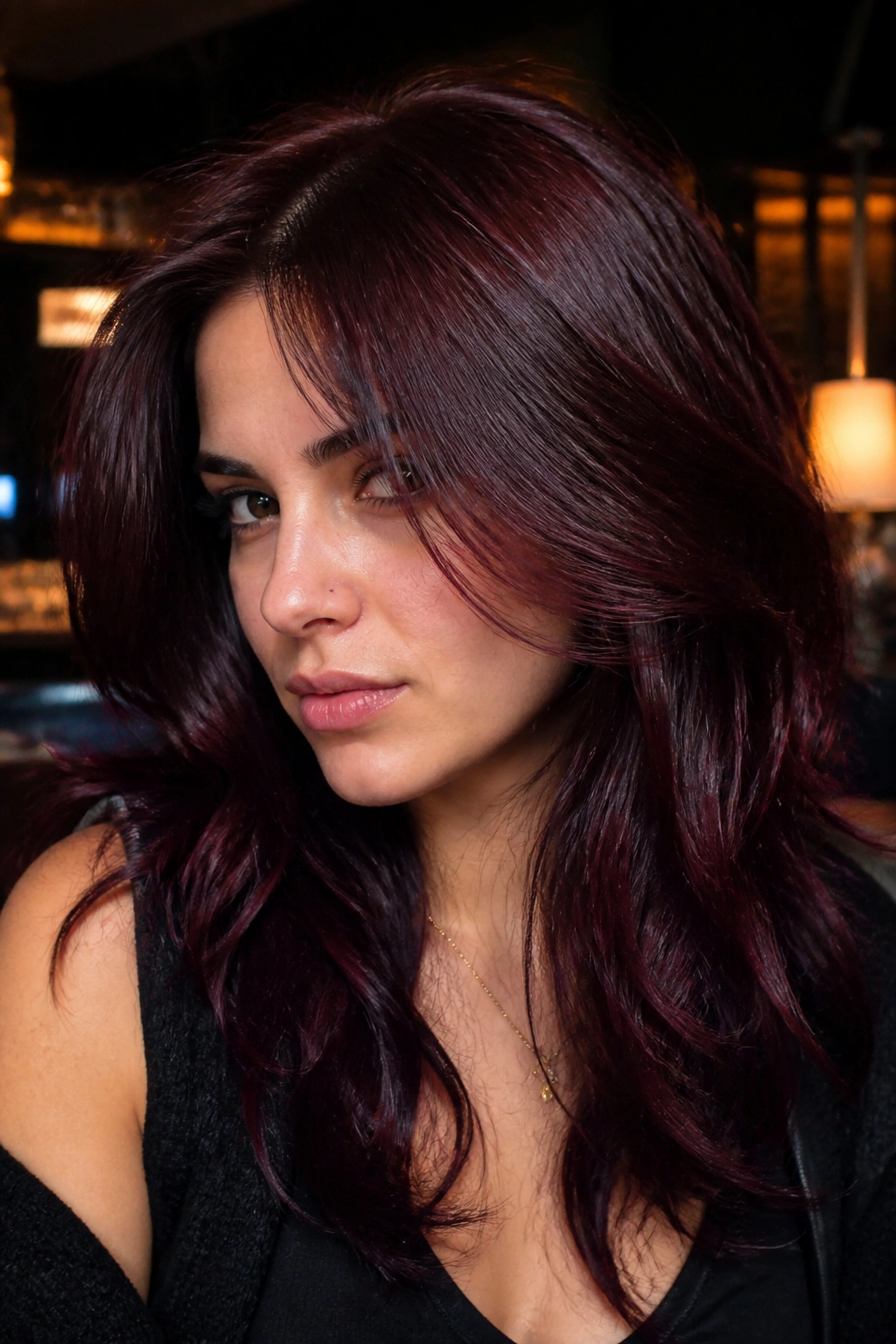 Close-up of a real person with Black Cherry hair color showing deep wine tones and burgundy highlights.