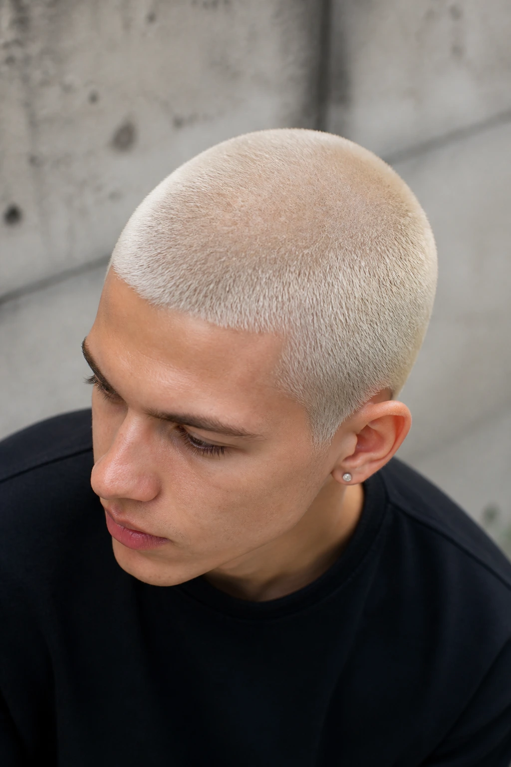 Close-up of a real person's platinum bleached buzz cut showing even lift