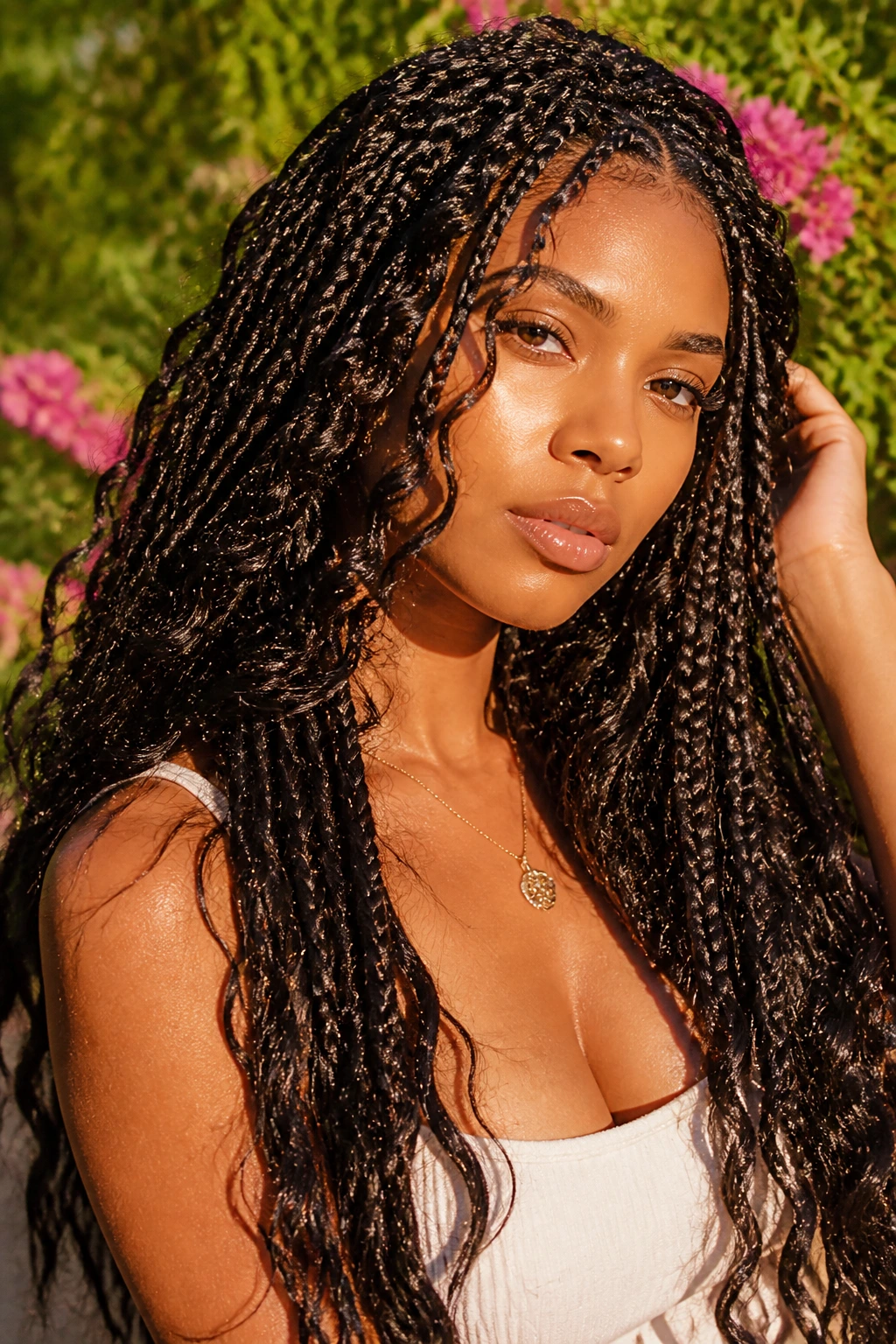 Real person with long boho goddess braids and loose waves in a sunny garden