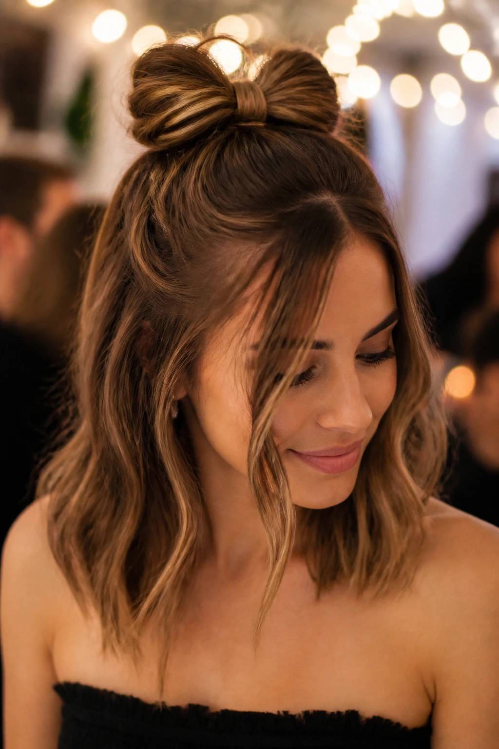 Real woman wearing a Bow Bun Half-Up hairstyle at a party setting.