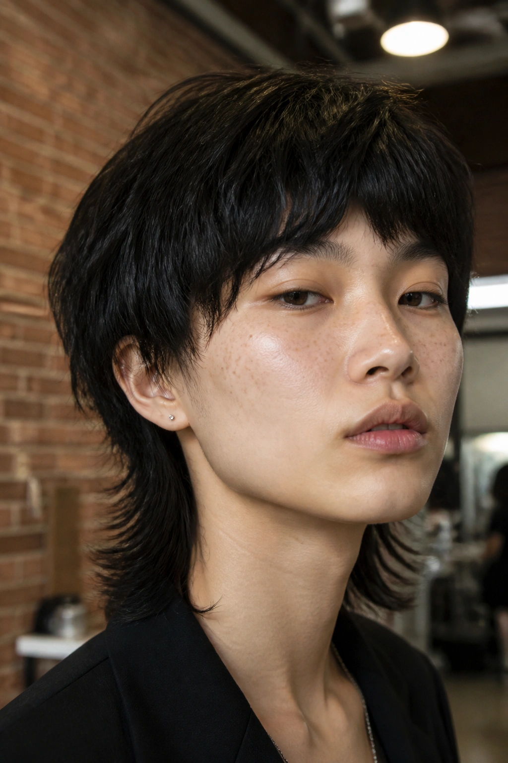 Close-up of a real person with a bowl-inspired wolf cut in a fashion studio backdrop