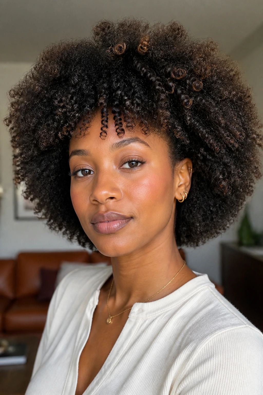 Real person with brushed-out curly afro showing defined roots and soft halo