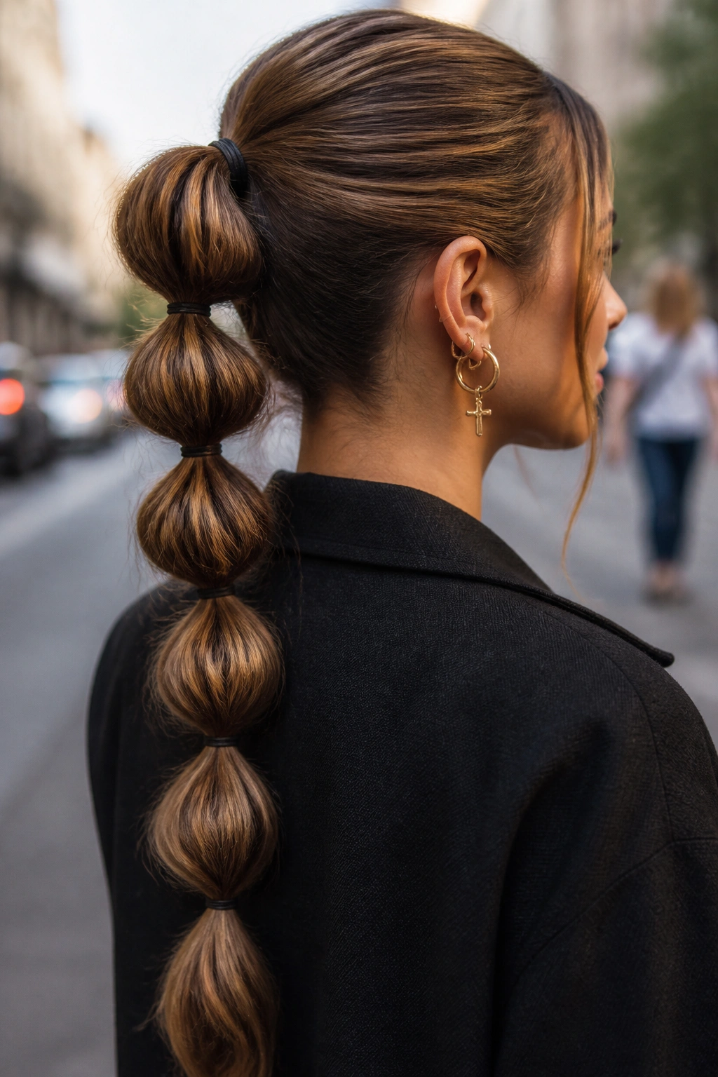 Close-up of a bubble braid along a ponytail on a real woman in an urban setting.