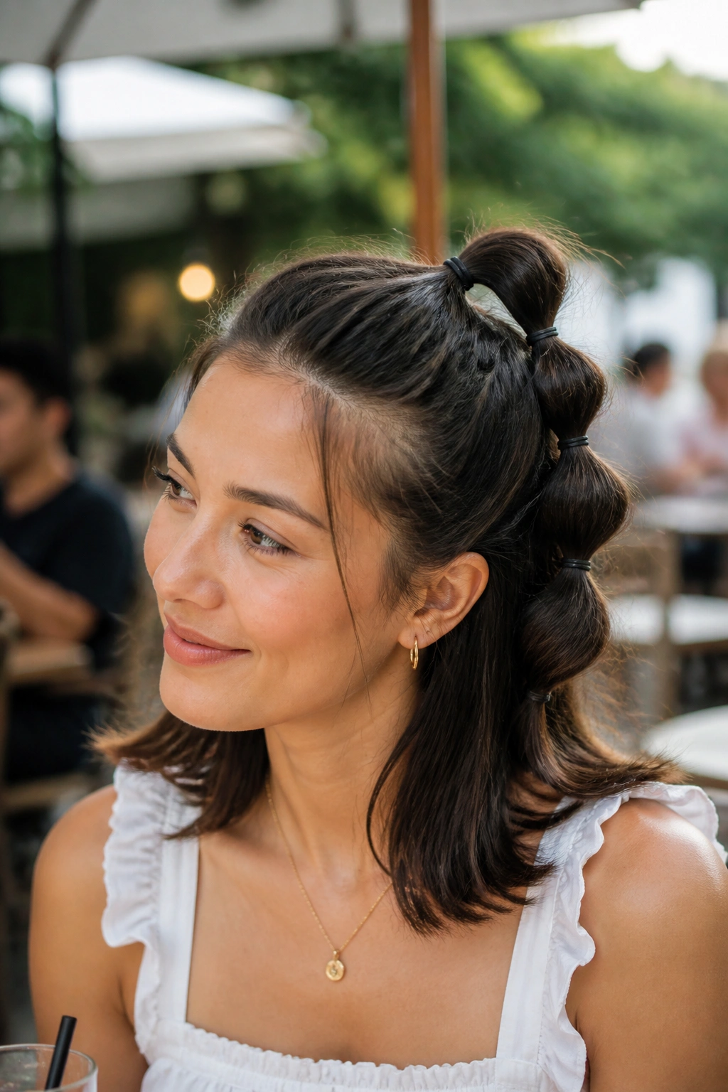 Close-up portrait of a real person showing a bubble half-up ponytail hairstyle.