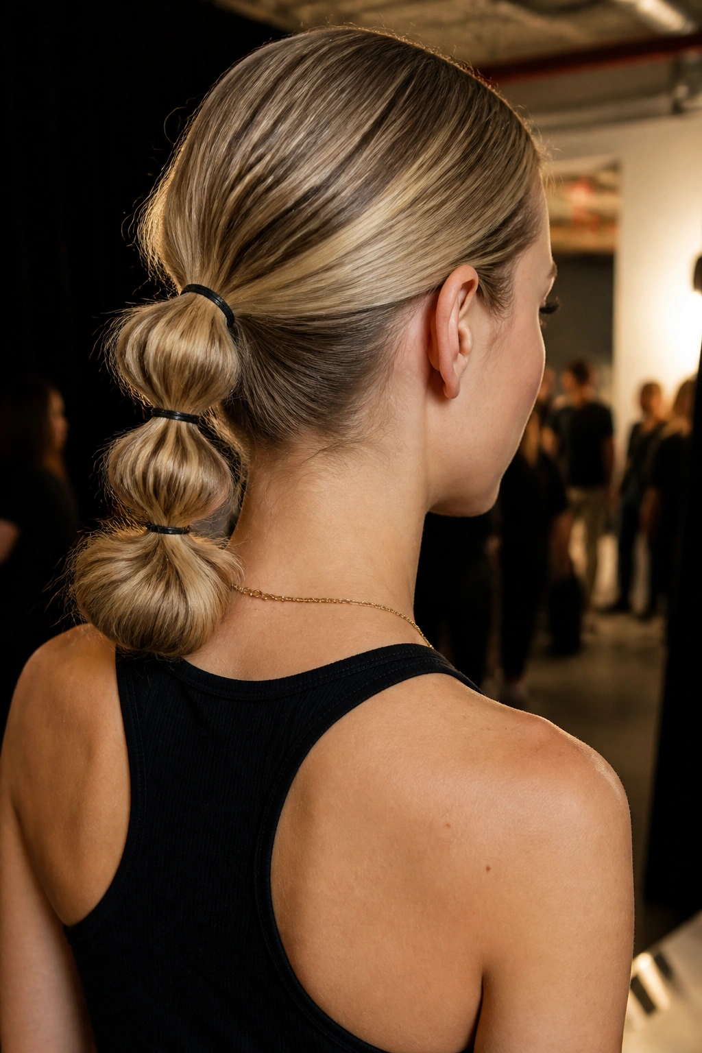 Rear view of a woman with a bubble ponytail ending in a bun