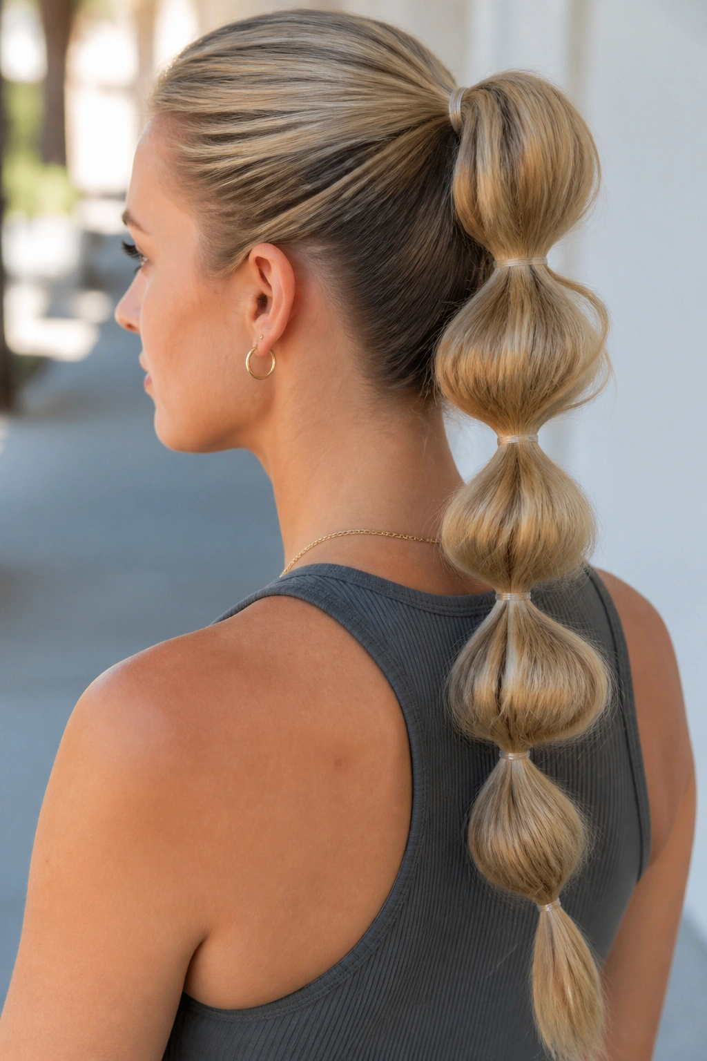 Back/side view of a woman with a bubble ponytail showing segmented sections