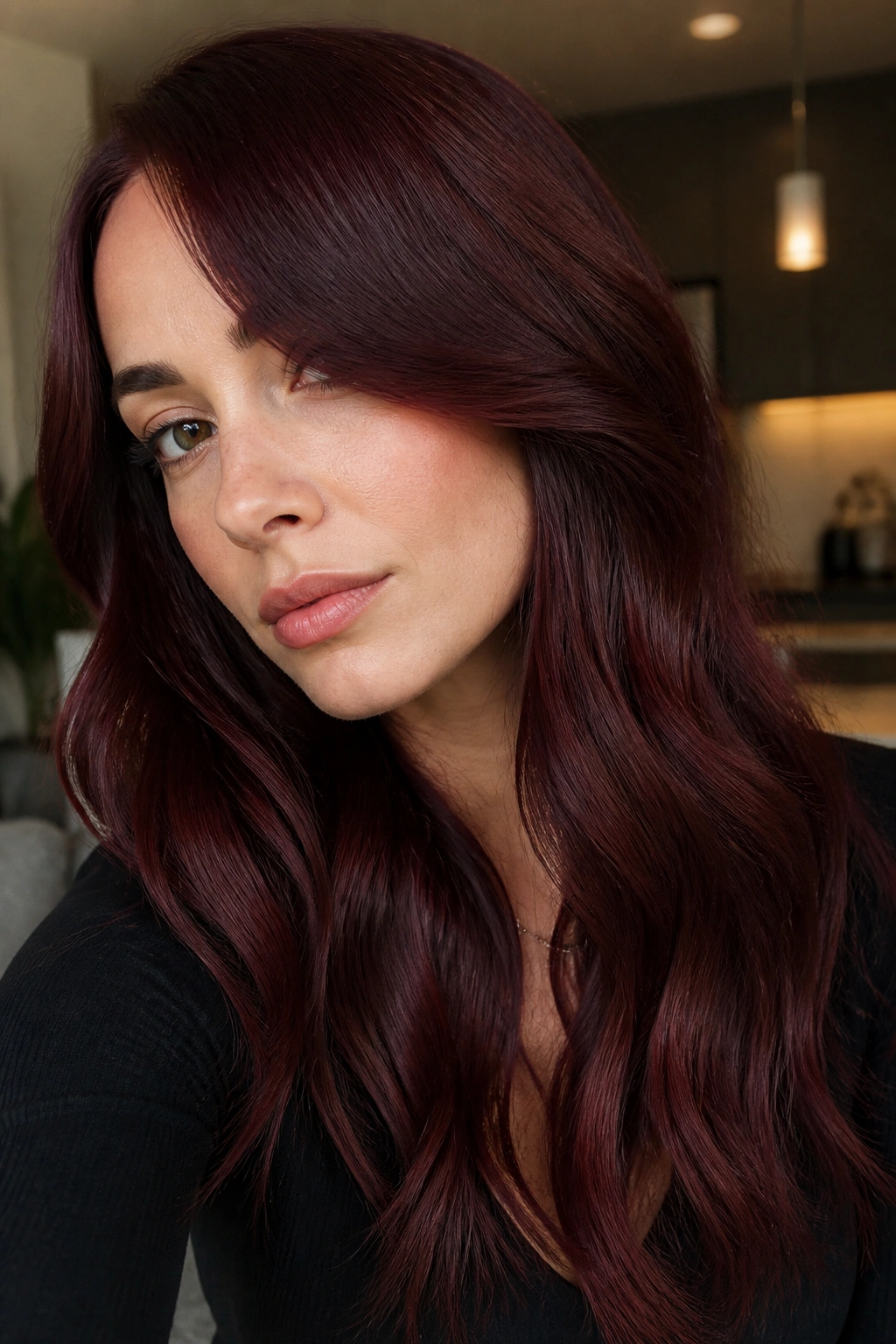 Close-up portrait of a woman with cherry cola hair under ambient light