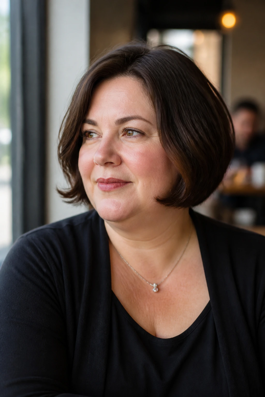 Real woman portrait with chin-length French bob and soft bend in warm daylight
