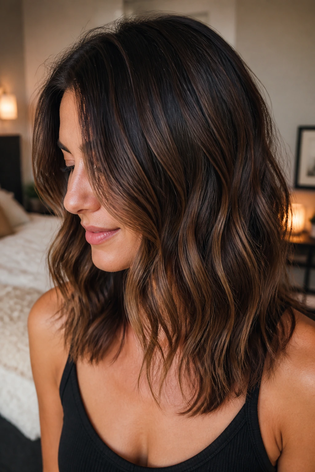 Close-up of real woman with chocolate balayage and growing-out roots in warm light