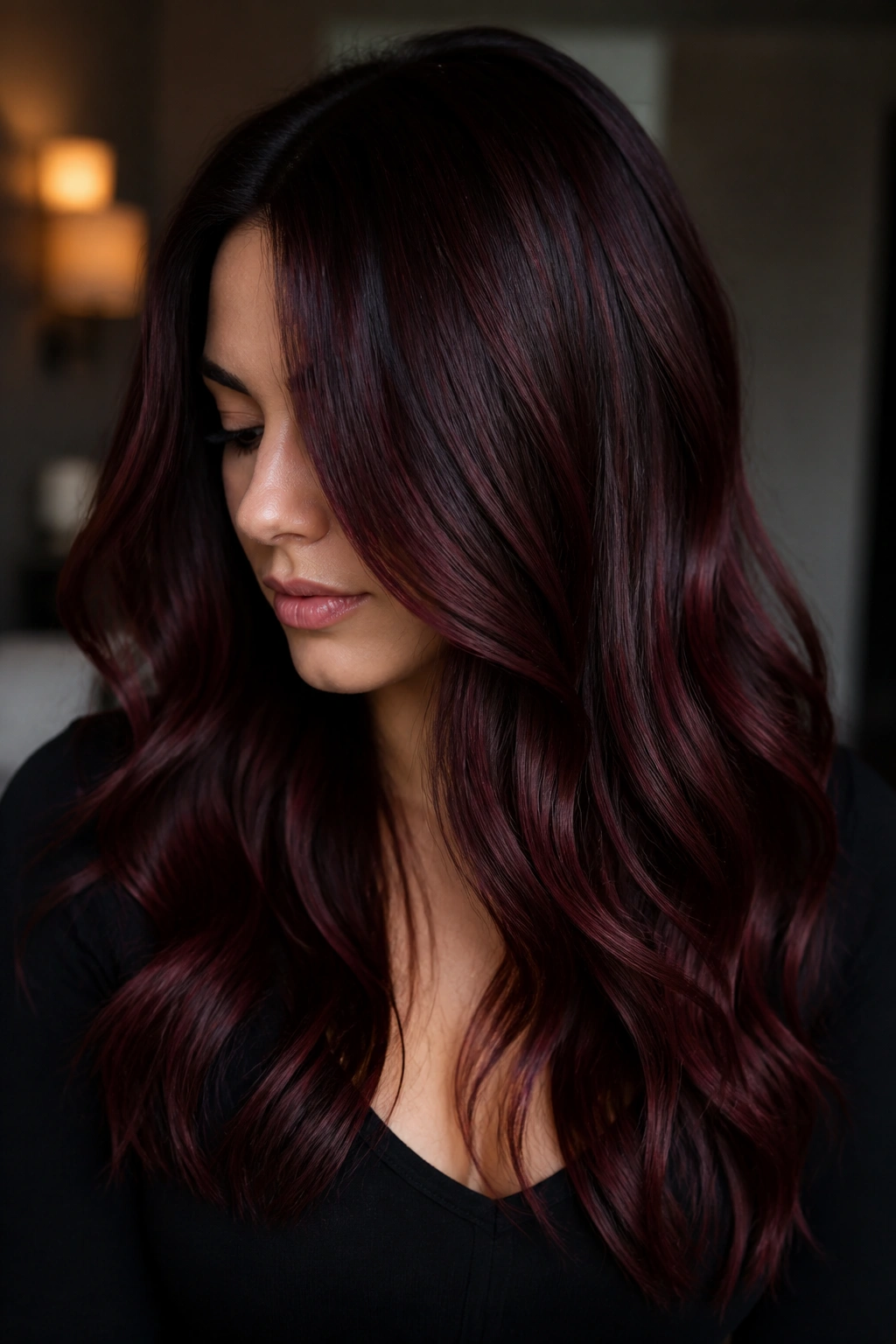 Close-up of real woman with chocolate cherry balayage showing subtle red-violet highlights