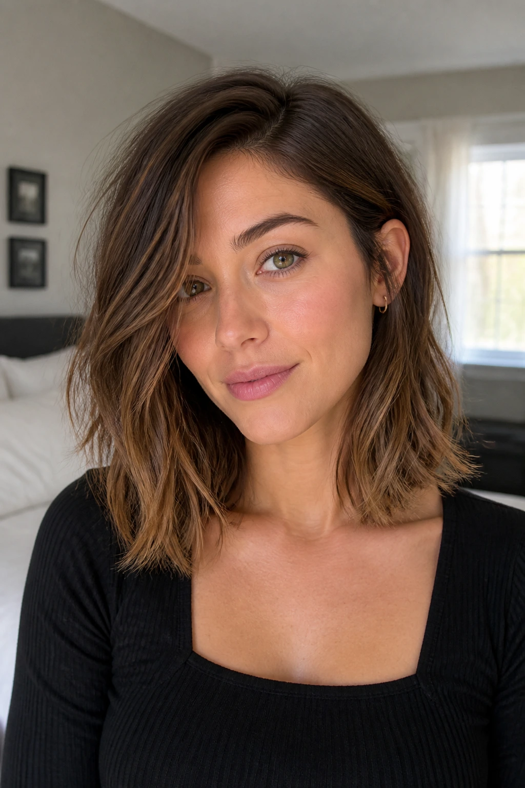 Portrait of a real woman with a choppy lob at collarbone length and a tucked behind ear detail.