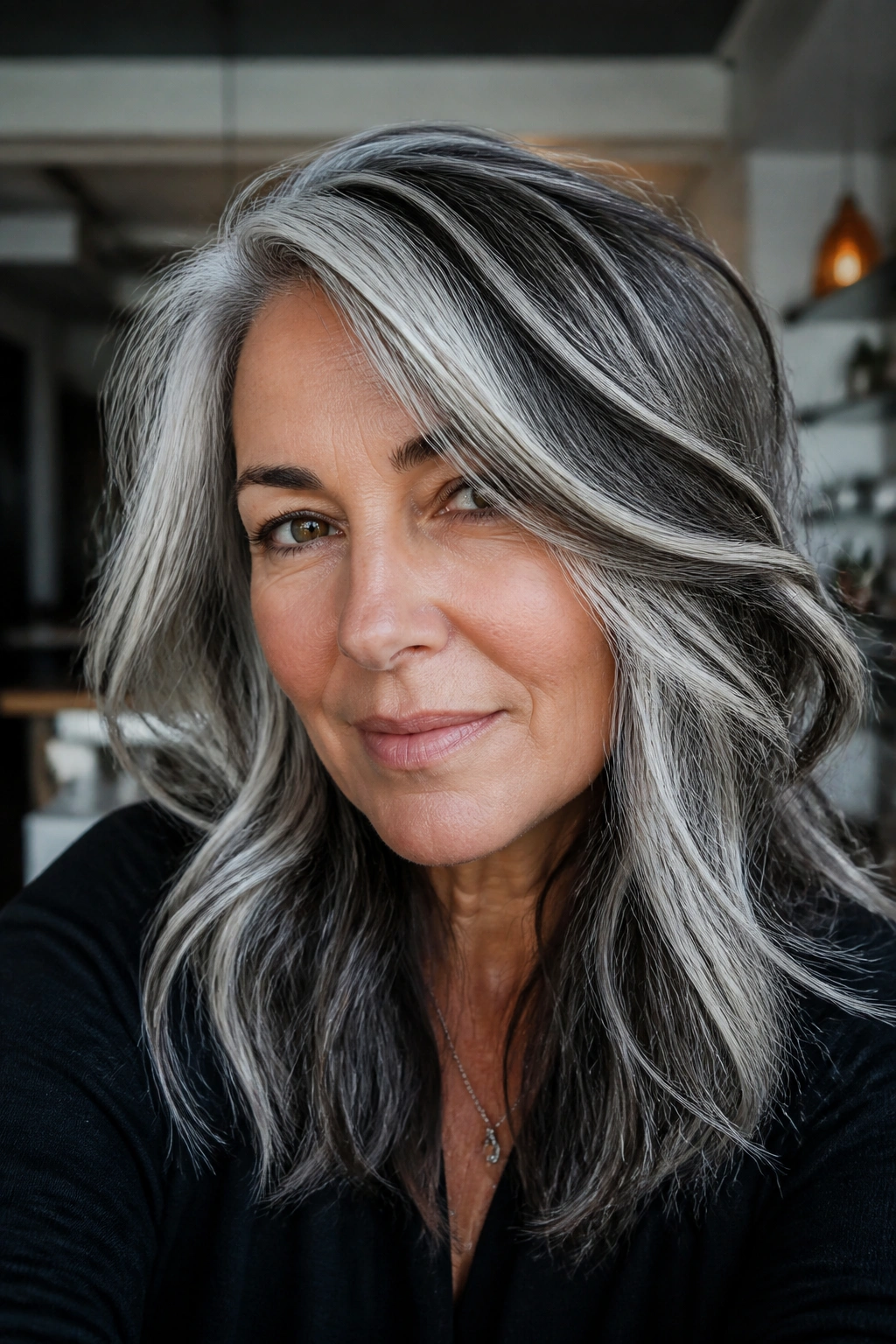 Close-up portrait of a real person with chunky charcoal streaks in salt-and-pepper hair.