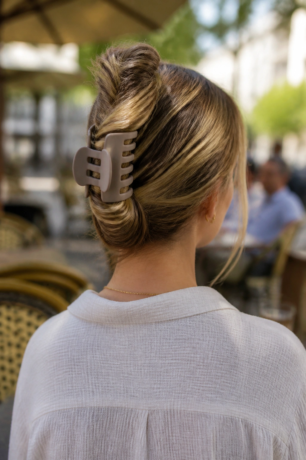 Back view of a real woman with hair twisted and secured with a large claw clip.