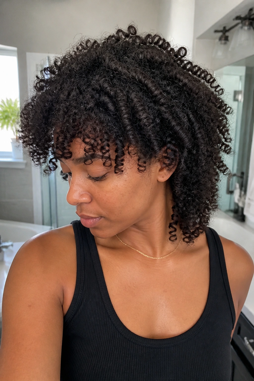 Close-up of real person with curly wolf cut for coily hair showing shrinkage.