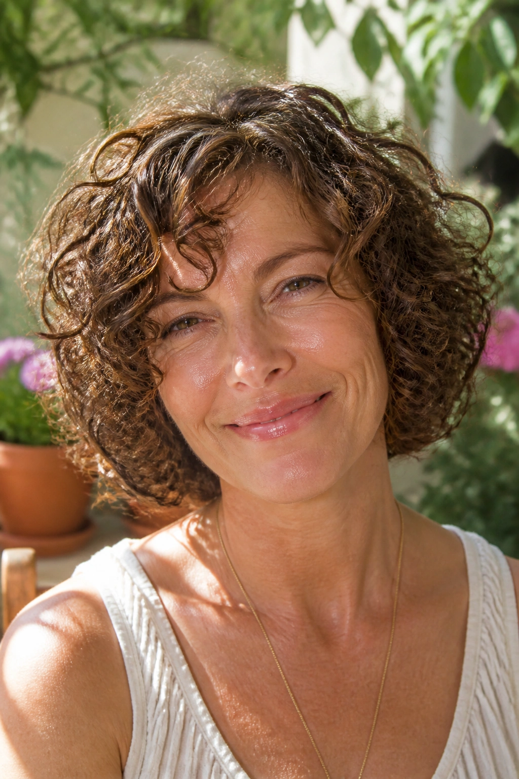 Real woman with chin-length curly bob in a sunny garden setting