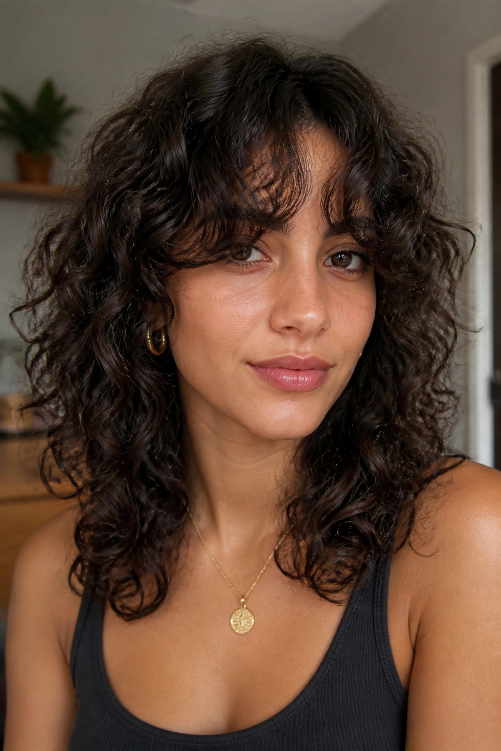 Portrait of a real woman with curly curtain bangs that blend into the sides.