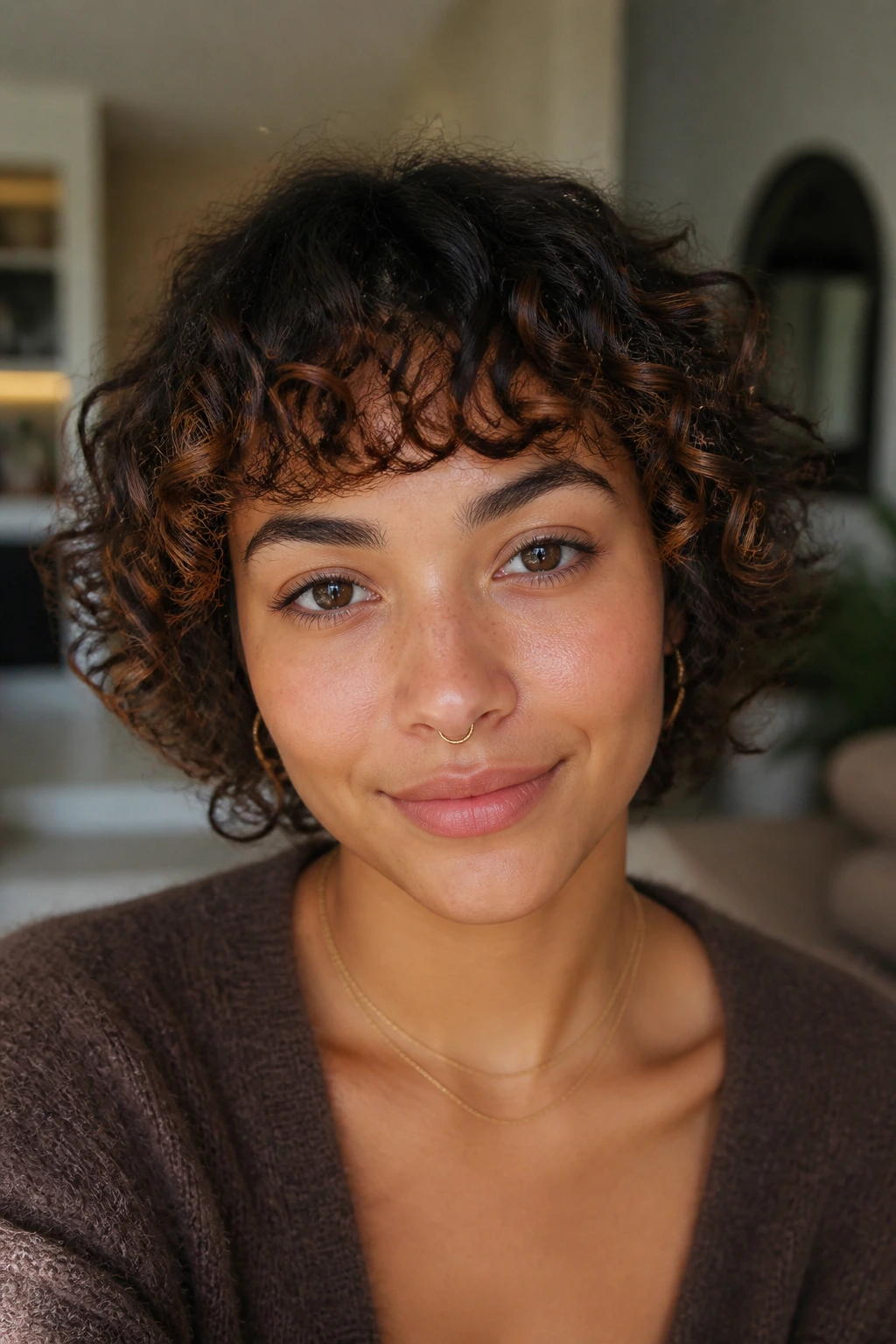 Close-up of curly micro fringe with cinnamon lights on a real woman