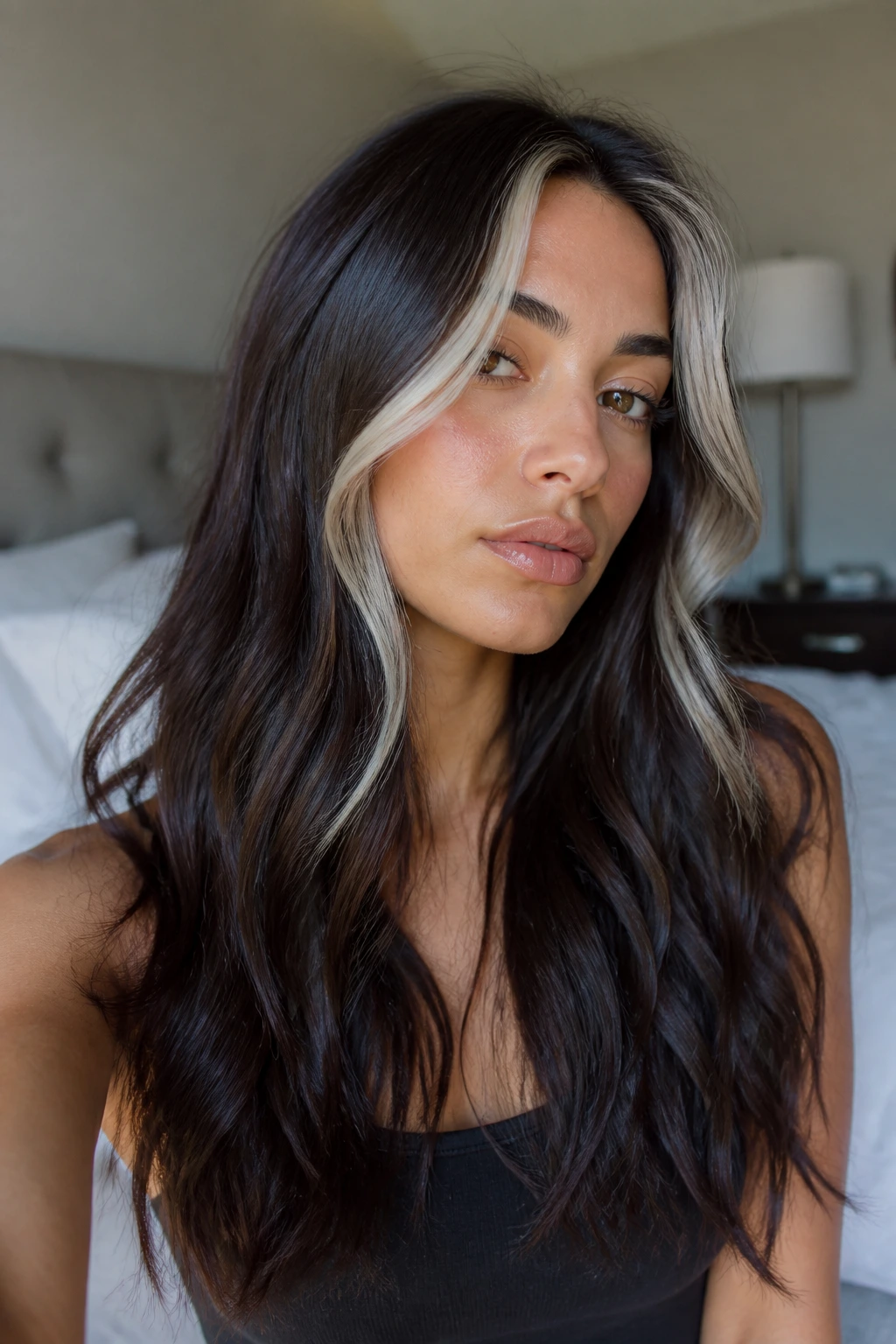 Close-up portrait of a real person with a deep brunette base and platinum face-framing streaks around the cheeks.