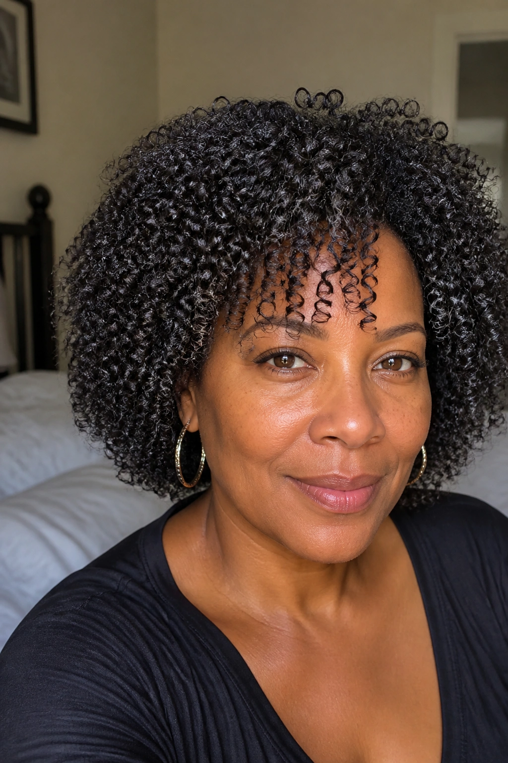 Close-up portrait of a real woman with defined curls in a wash-and-go style.
