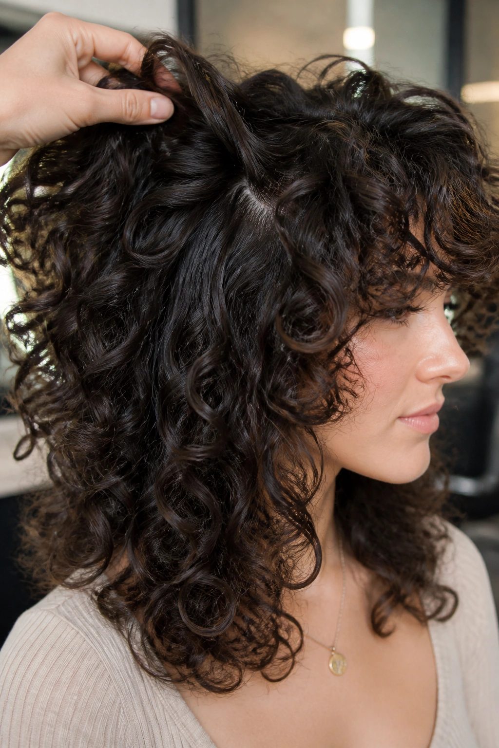 Close-up of a real person with dense ringlets and visible interior layers at the crown.