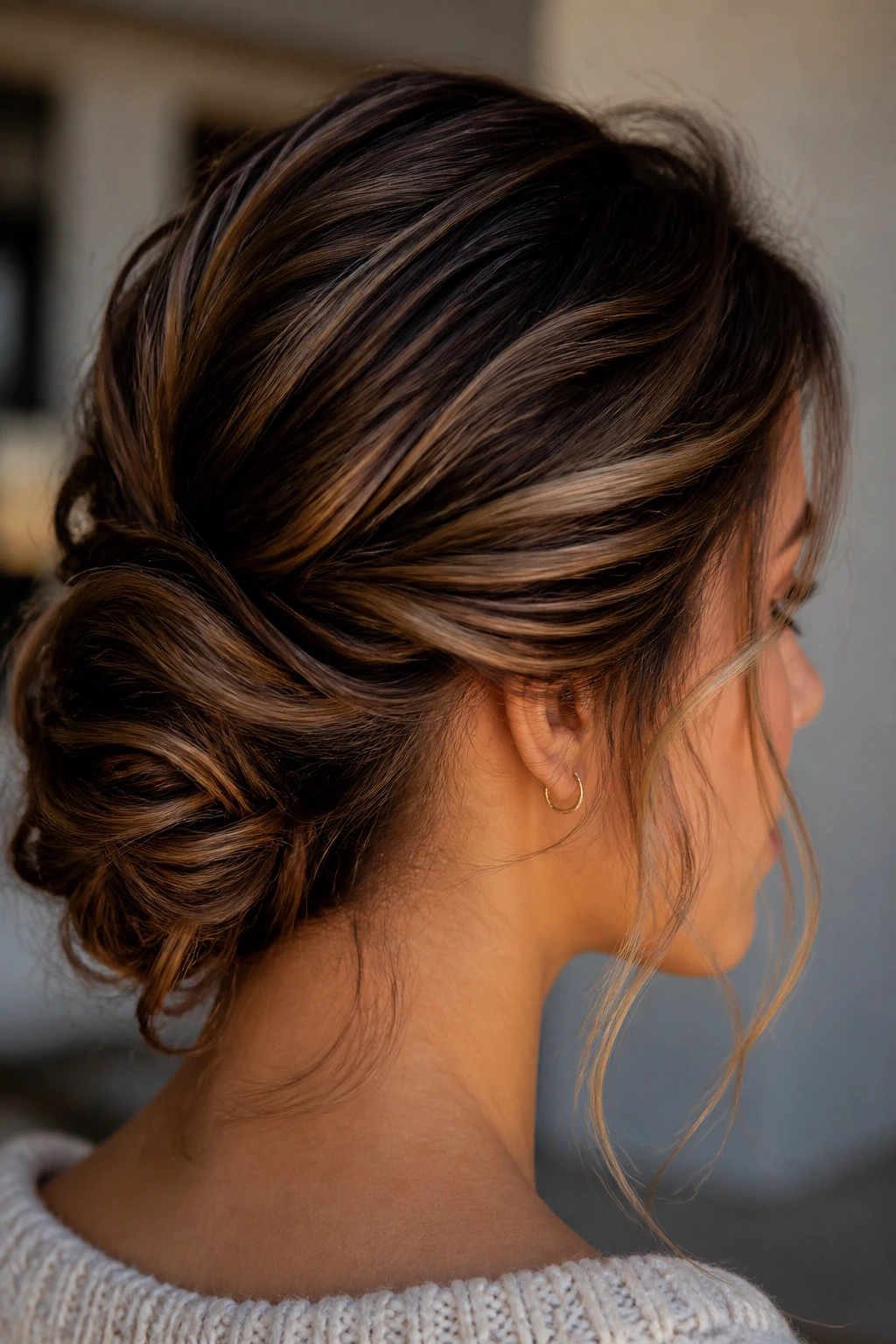 Close-up of a real woman with a soft bun showing dimensional brunette shine