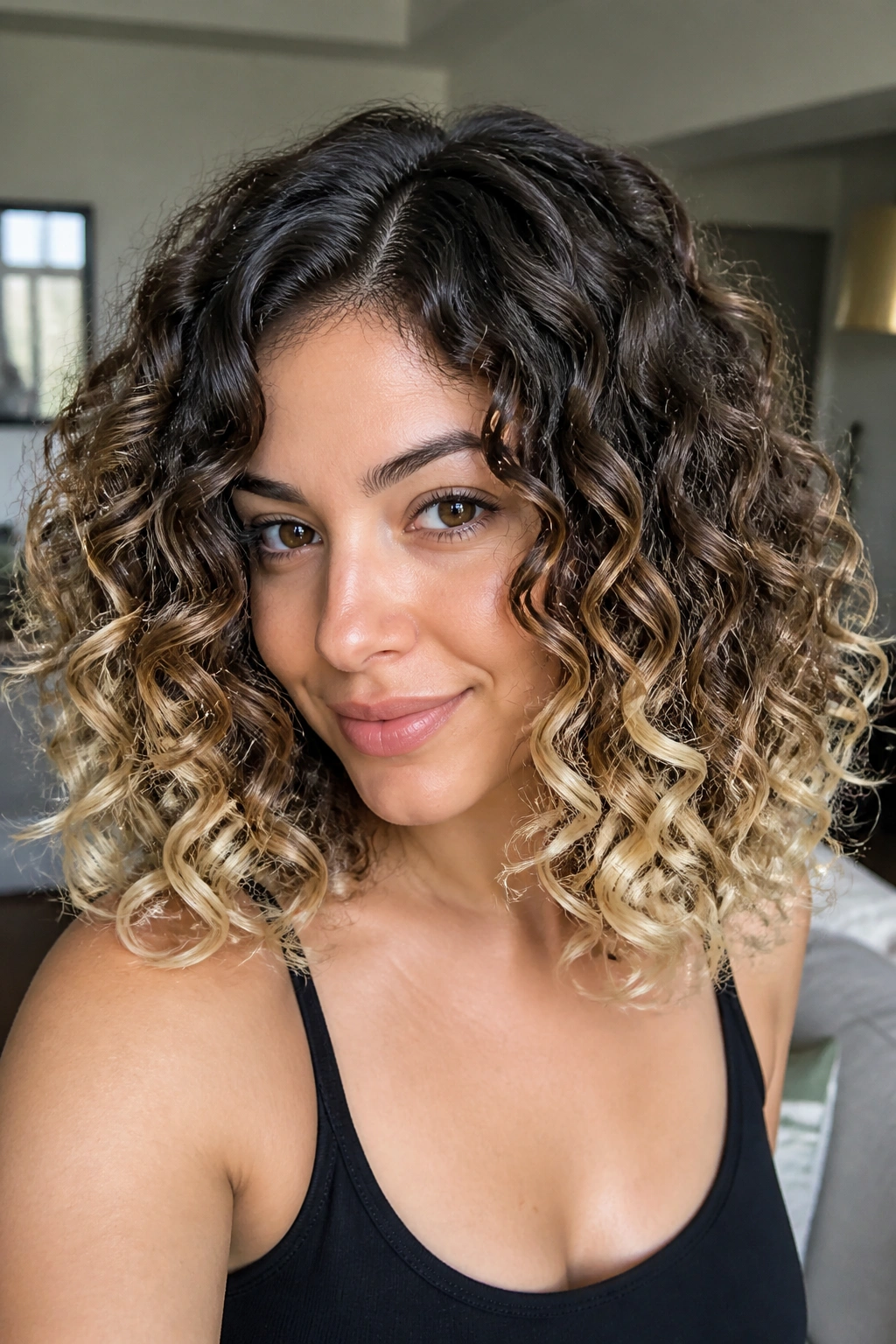 Curly hair with buttery dip-dye ends and dark roots