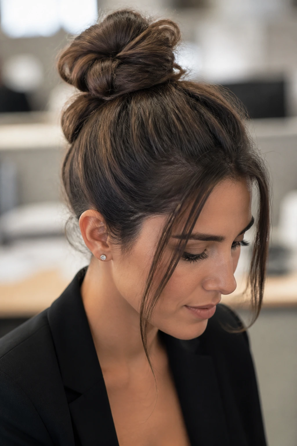 Close-up of a real woman with a double-knotted bun in an office