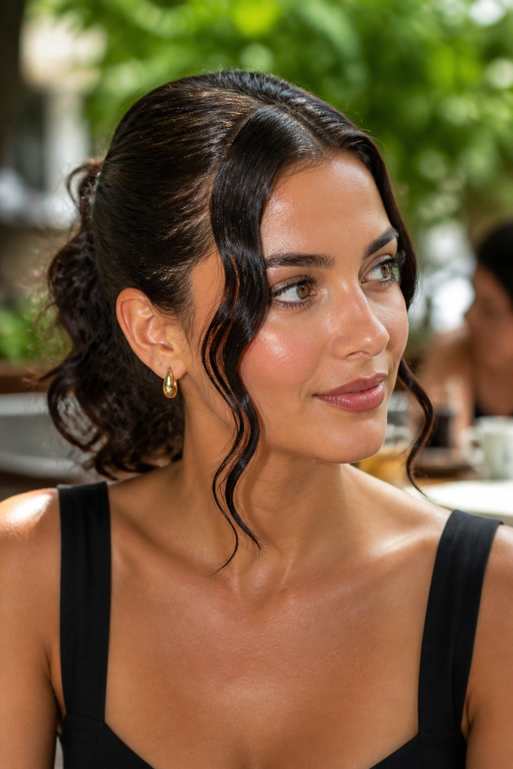 Close-up of a real woman with face-framing gel waves and glossy front pieces in sunny outdoor light