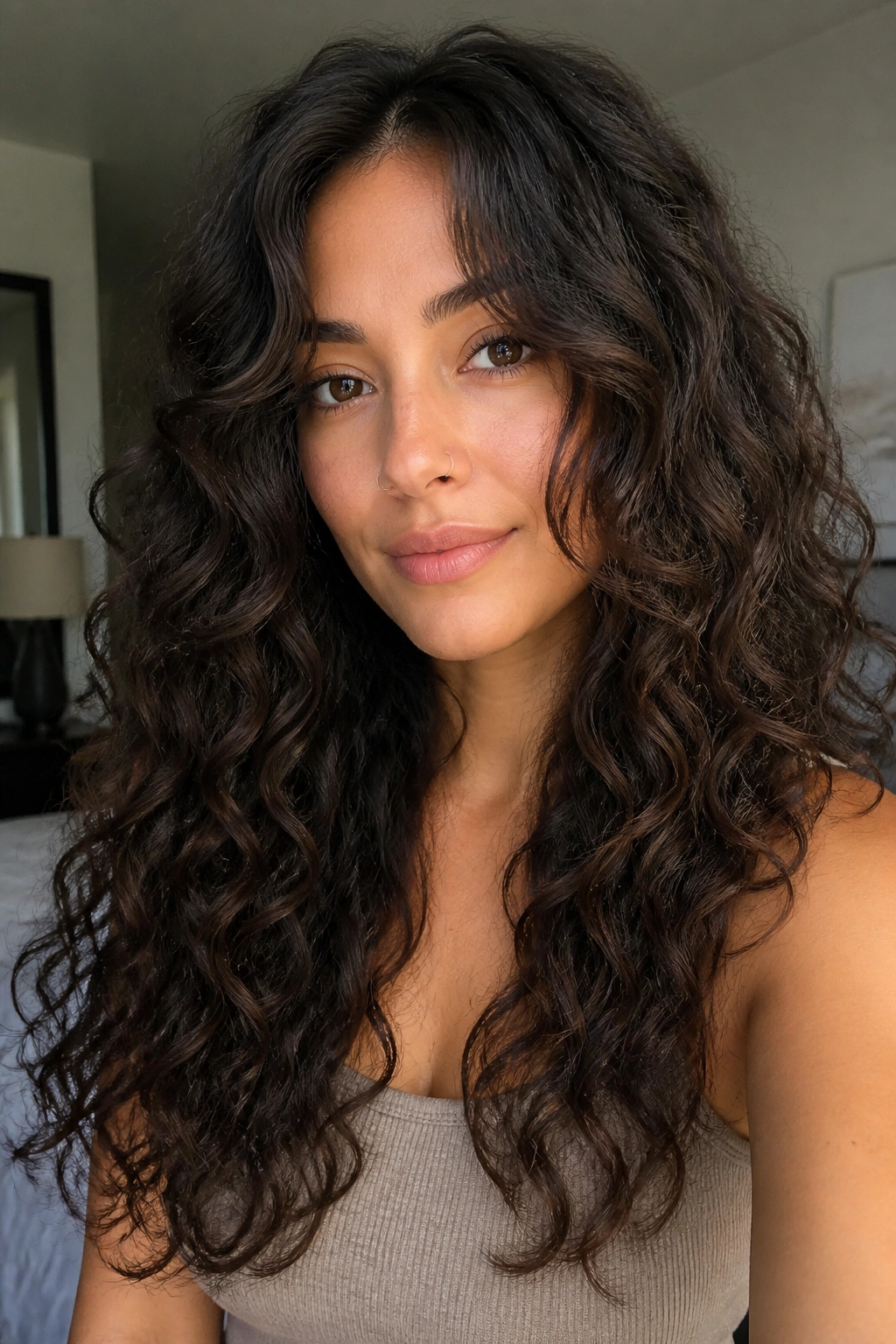Close-up portrait of a real woman with face-framing curls around the cheeks