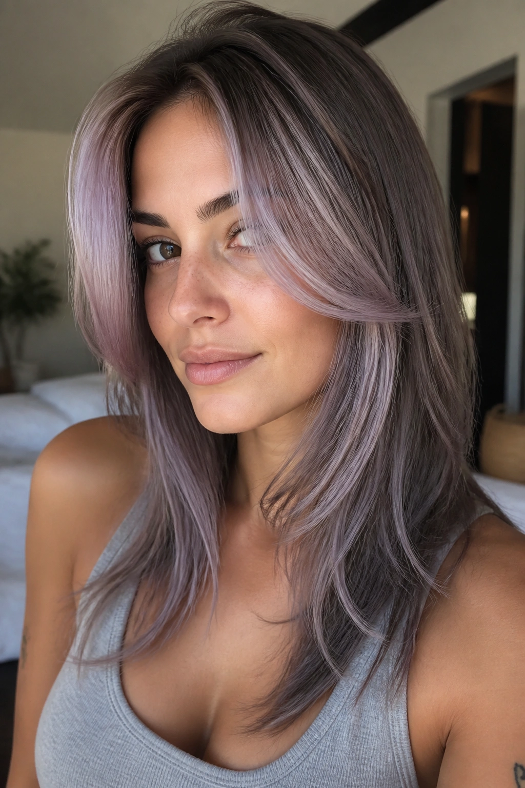 Close-up portrait of face-framing lilac grey layers on a real woman.
