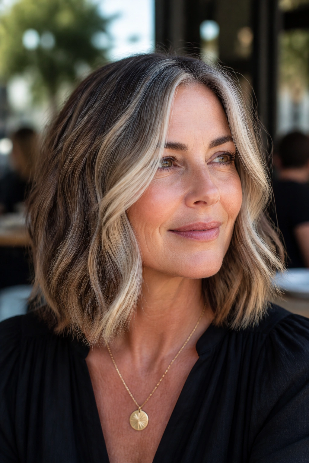 Medium close-up of a woman with a wavy lob and face-framing pieces