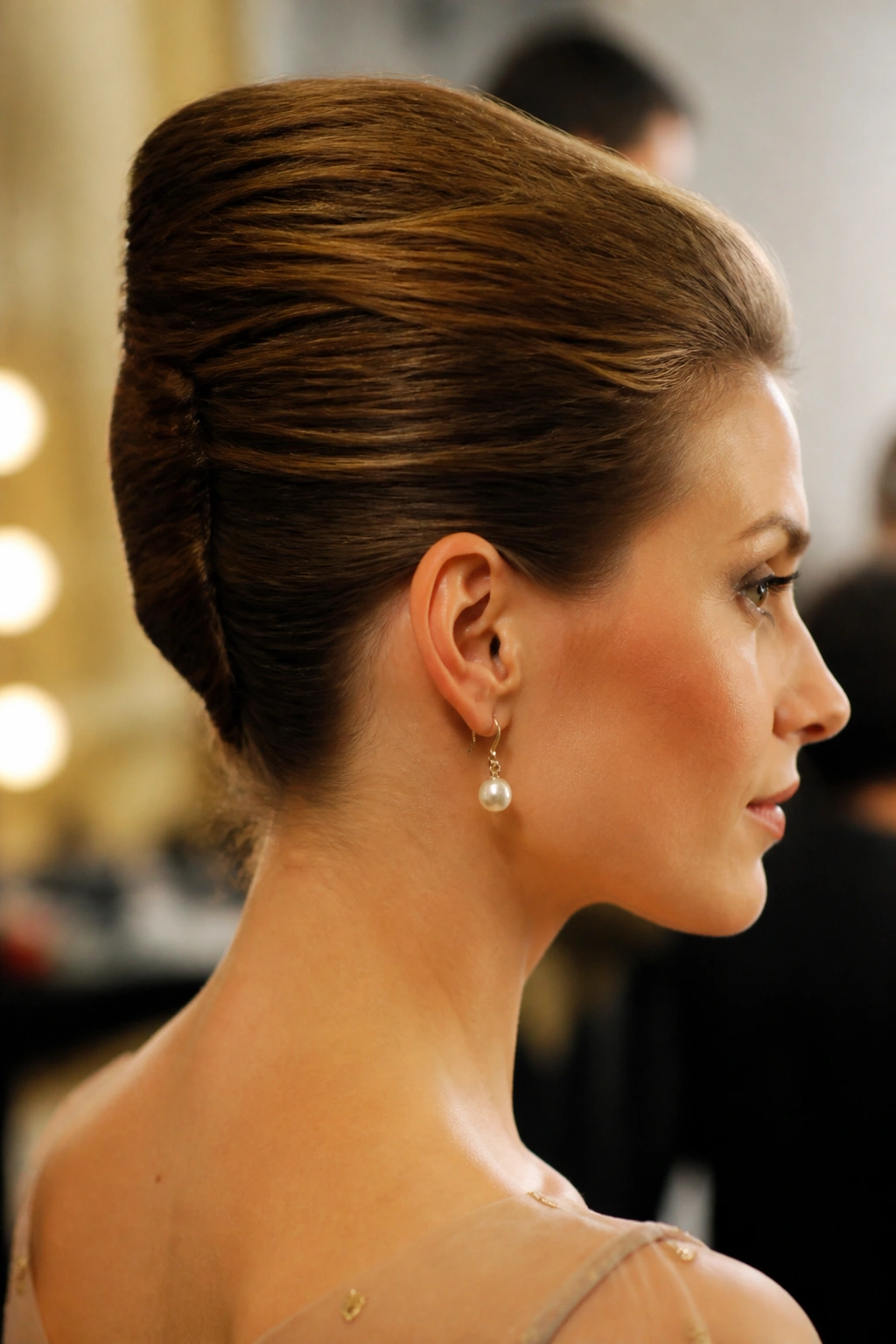 Close-up of a real woman with a French Twist hairstyle seen from the back and side