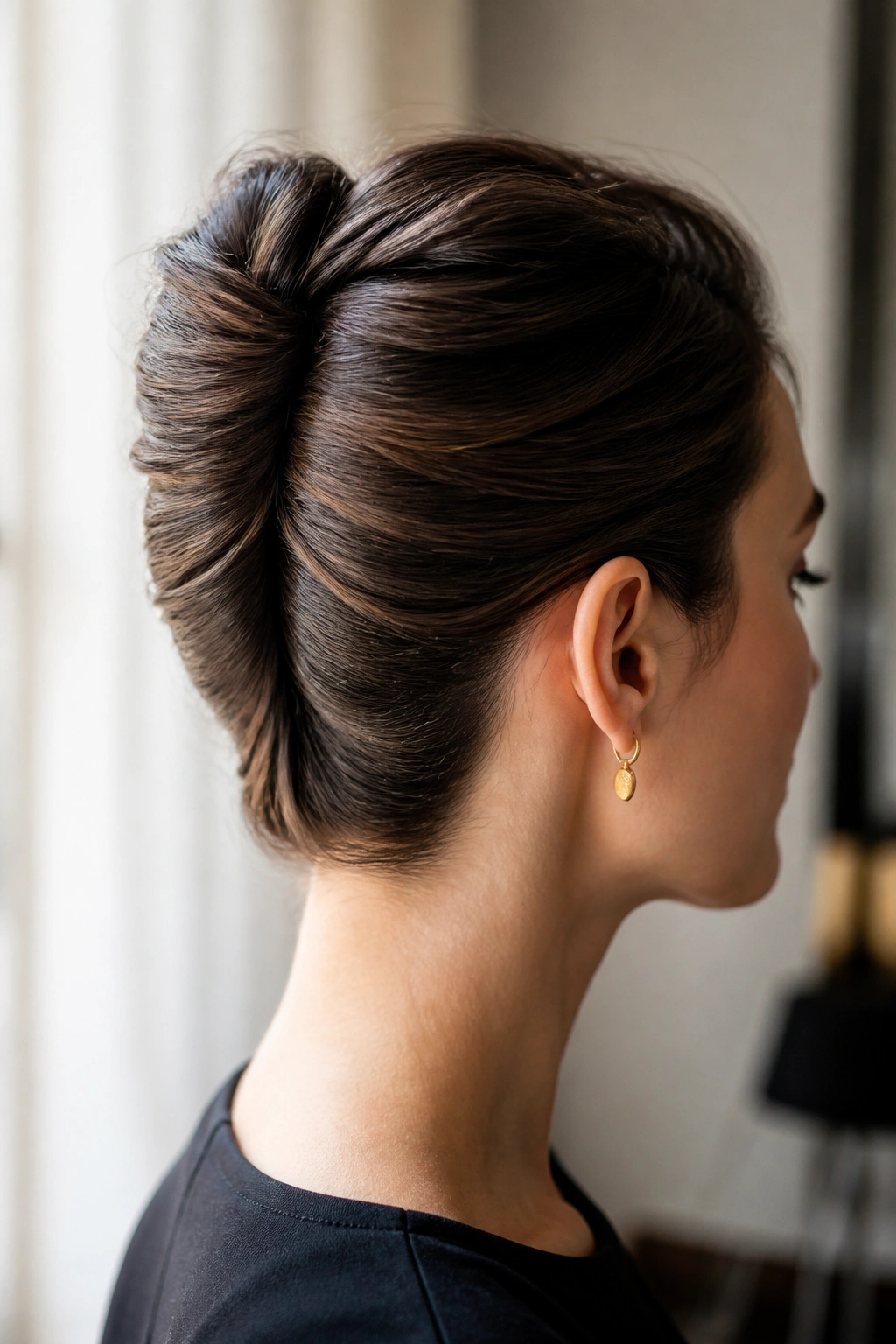 Side profile of a real woman wearing a French twist for straight hair.
