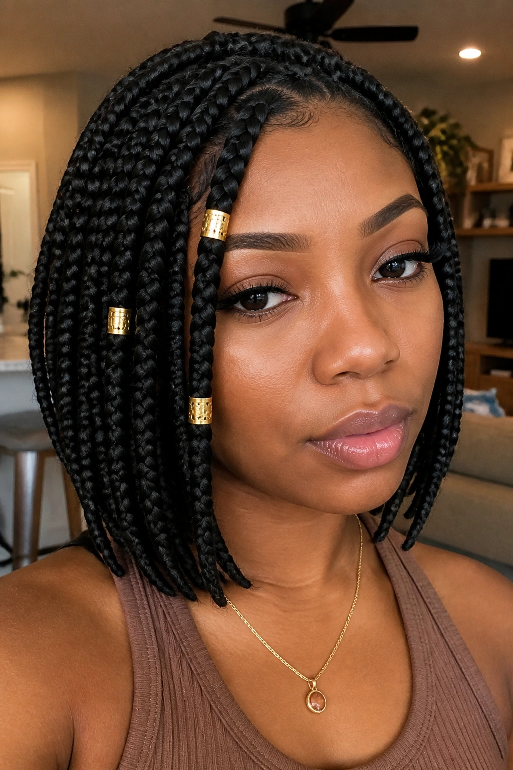Close-up of a real woman with gold cuffs on front braids in a bob hairstyle