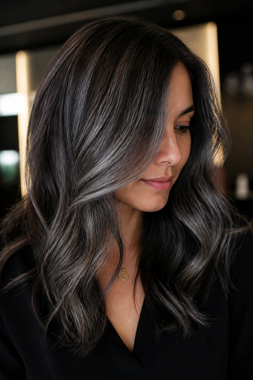Portrait of a woman with graphite grey highlights on brown hair under moody lighting