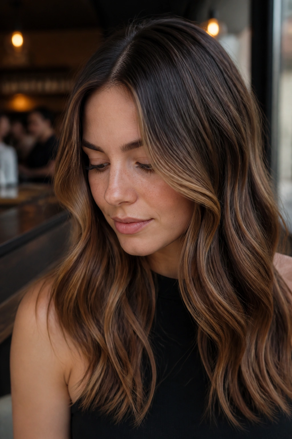 Close-up of hazelnut ribbon balayage on hair in a cafe setting