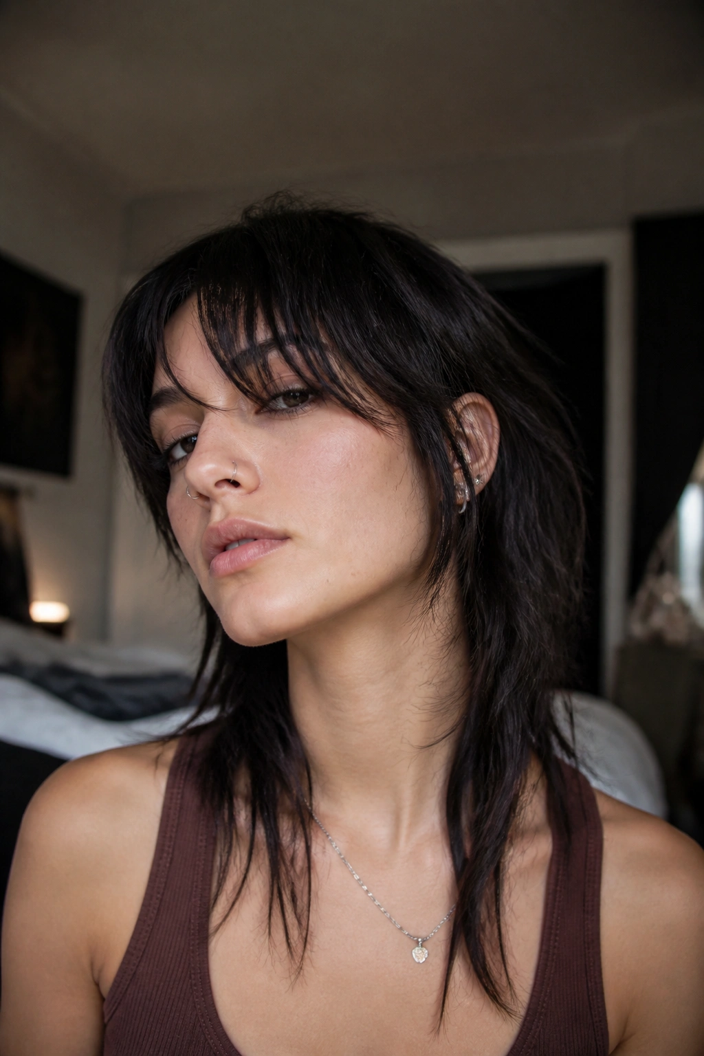 Close-up portrait of a real person with uneven-length indie wolf cut and asymmetrical curtain bangs.