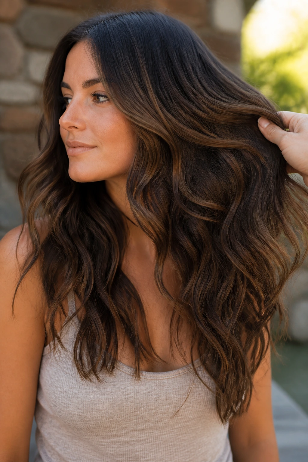 Close-up of a real woman with thick wavy hair showing internal layers