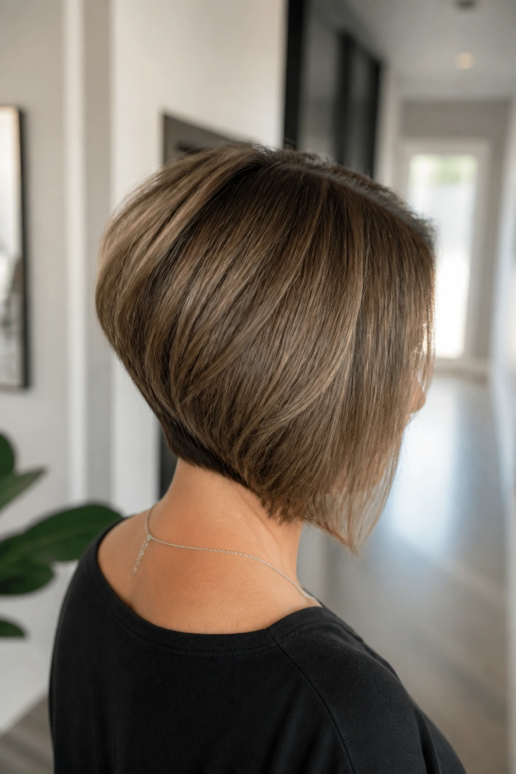 Rear three-quarter view of real woman with inverted bob and hidden layers