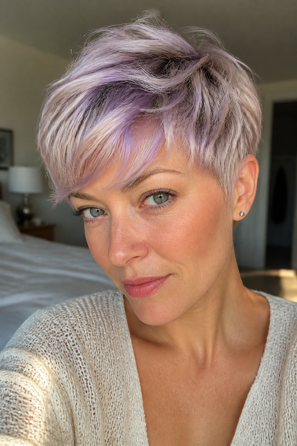 Close-up portrait of a person with soft lilac highlights on a textured pixie