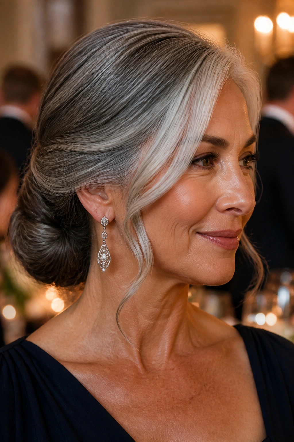 Portrait of a woman with a low chignon and silver face pieces.