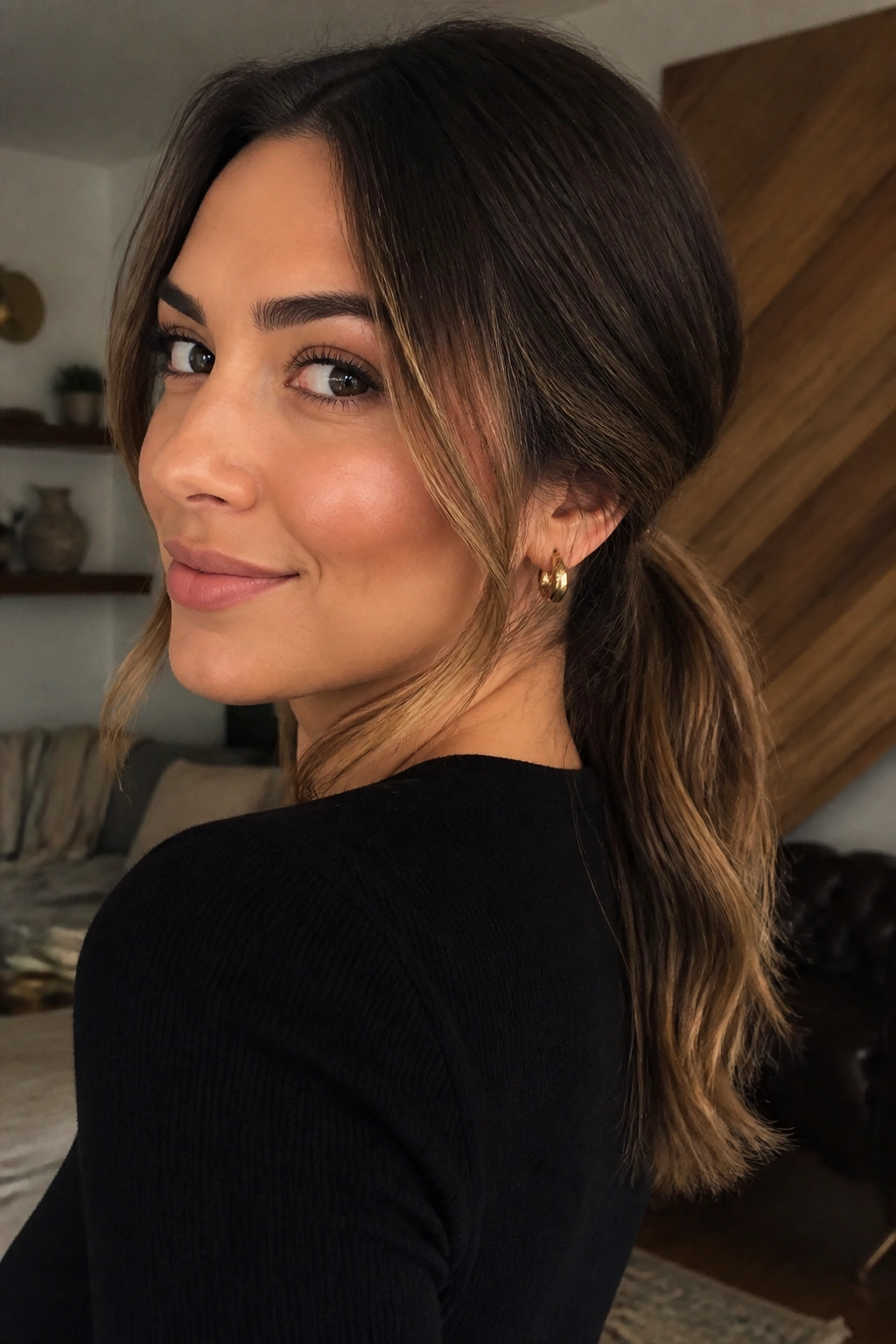 Close-up portrait of a real woman with a low ponytail showing hidden highlights beneath the top layer