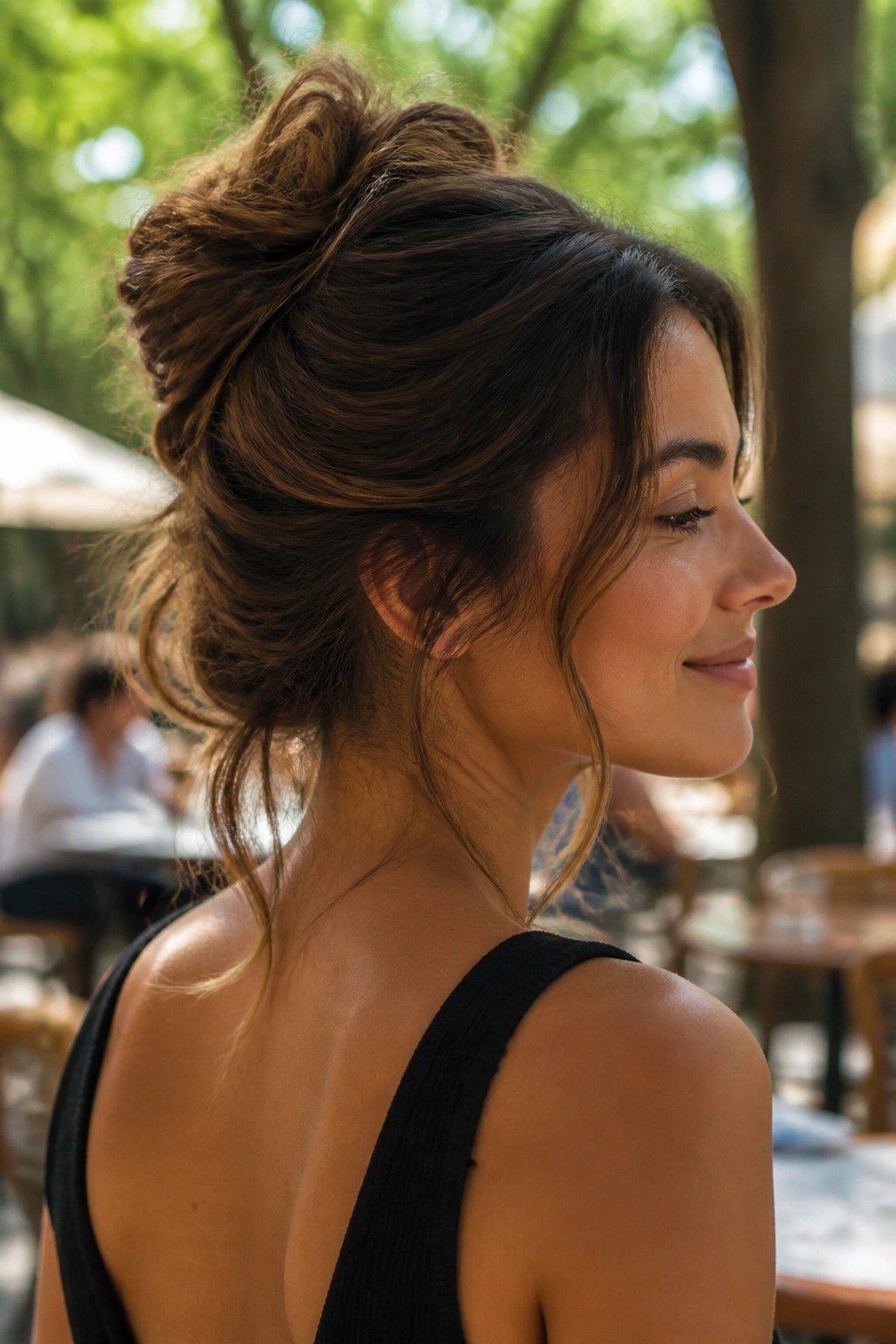 Close-up portrait of a real woman with a messy French twist bun and soft ends outdoors