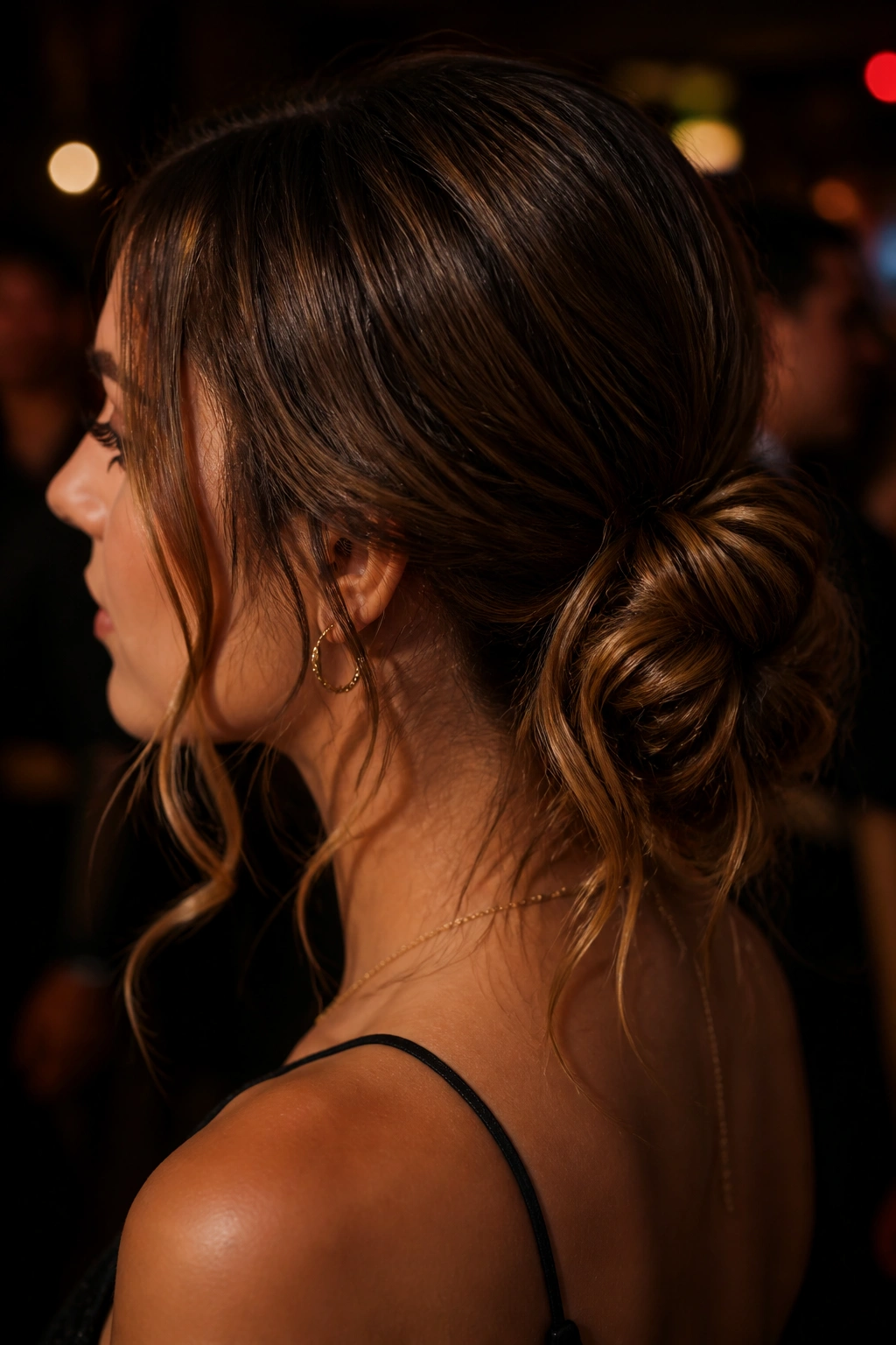 Close-up of a real woman with a messy knot and face-framing tendrils